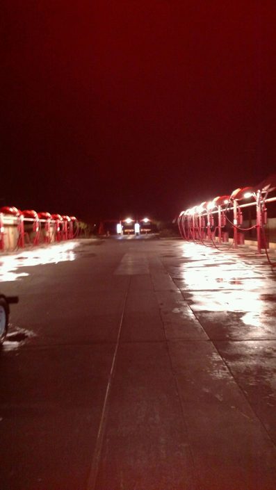 A long walkway with lights on the side of it.