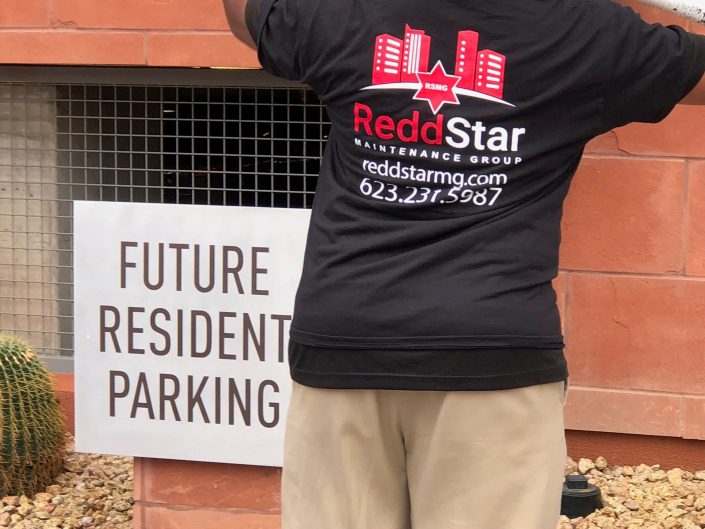 A man standing in front of a building with his back turned.