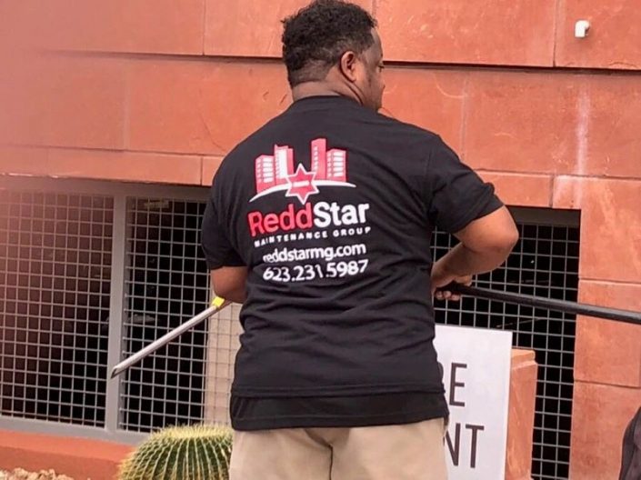 A man in black shirt holding a mop.