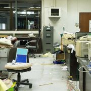 A messy office with many items on the floor.